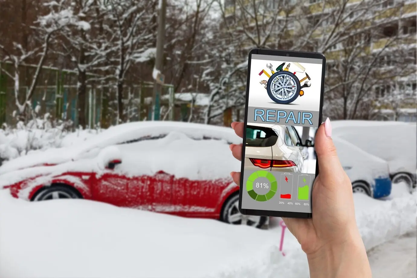 Hand holding a mobile phone with a blurred car repair service center in the background.